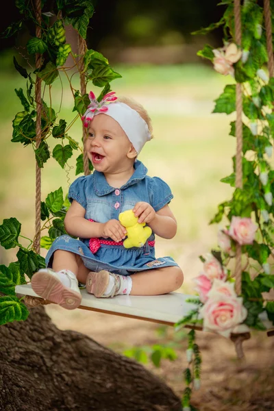 Schönes kleines Mädchen auf Schaukel sitzend — Stockfoto