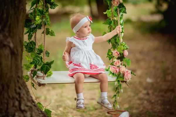 Schönes kleines Mädchen auf Schaukel sitzend — Stockfoto