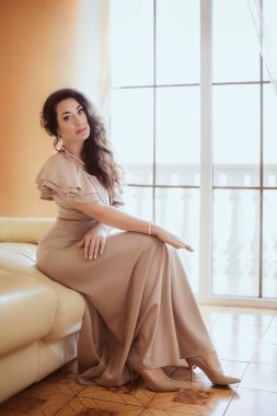 Yatak odasında bej elbiseli kadın