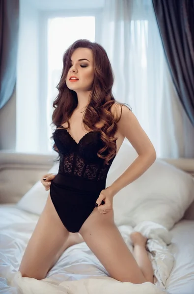 Sexy mooie brunette meisje in slaapkamer — Stockfoto