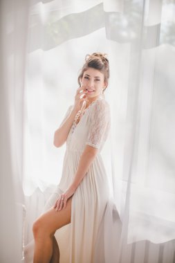 Güzel esmer kız beyaz yatak odasında 