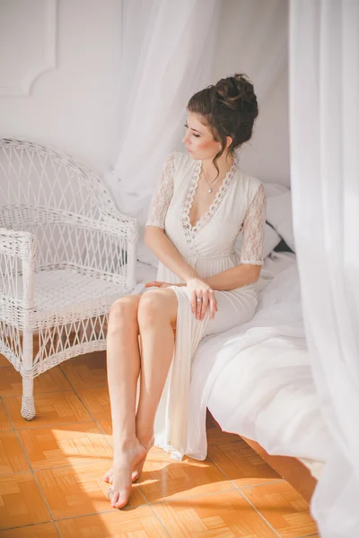 Kaunis brunette tyttö valkoinen makuuhuone — kuvapankkivalokuva