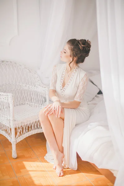 Beautiful brunette girl in white bedroom — Stock Photo, Image