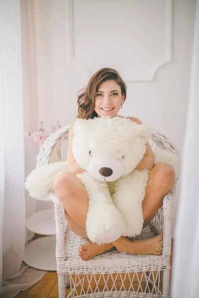 Brunette meisje met speelgoed beer in slaapkamer — Stockfoto