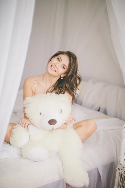 Menina morena com urso de brinquedo no quarto — Fotografia de Stock