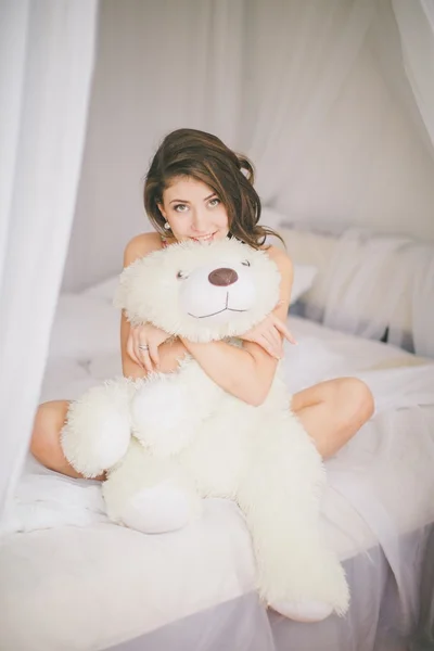 Menina morena com urso de brinquedo no quarto — Fotografia de Stock
