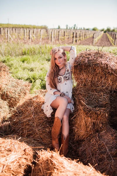 Красивая девушка на сене в поле — стоковое фото