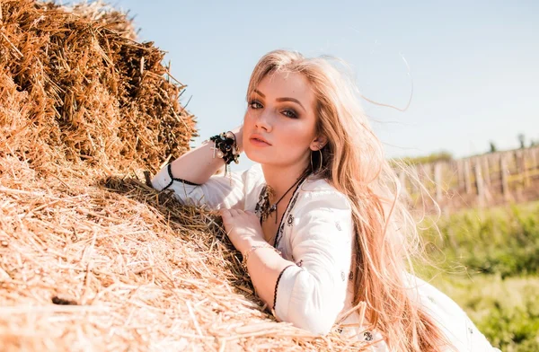 Chica posando cerca del heno en el campo — Foto de Stock