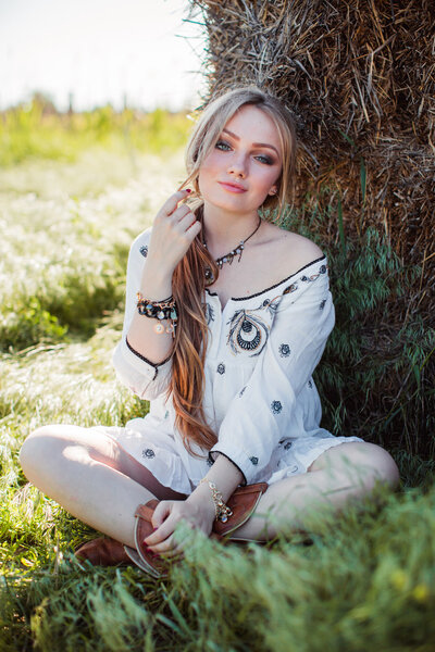 Girl posing near hay in the field