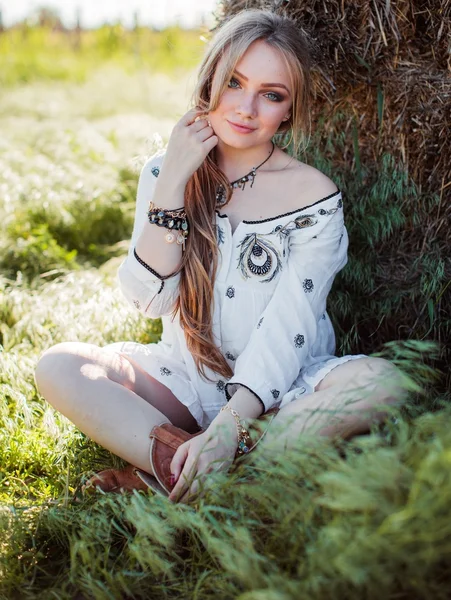 Meisje poseren in de buurt van hay in het veld — Stockfoto