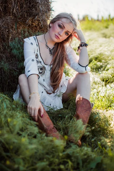 Девушка позирует возле сена в поле — стоковое фото