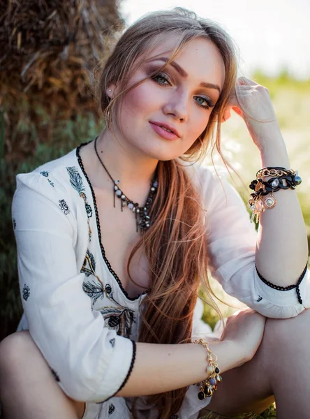 Girl posing near hay in the field — Stock Photo, Image