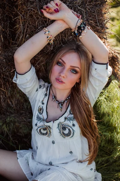 Girl posing near hay in the field — Stock Photo, Image