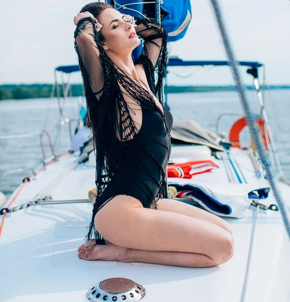 Женщина в черном купальнике на яхте — стоковое фото