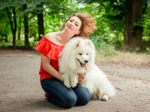 Samoyed köpek doğurmak parkta kadınla — Stok fotoğraf