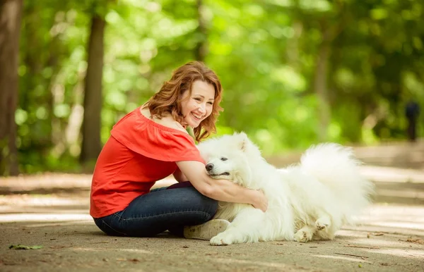 Kvinna med samojed hund rasen i parken — Stockfoto