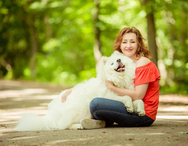 Mulher com raça cão Samoyed no parque — Fotografia de Stock