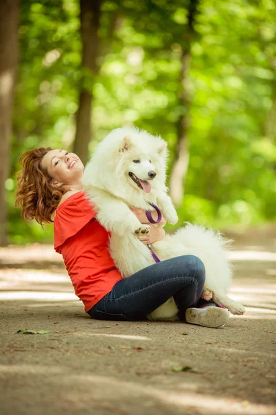 Donna con cane di razza Samoyed nel parco — Foto Stock