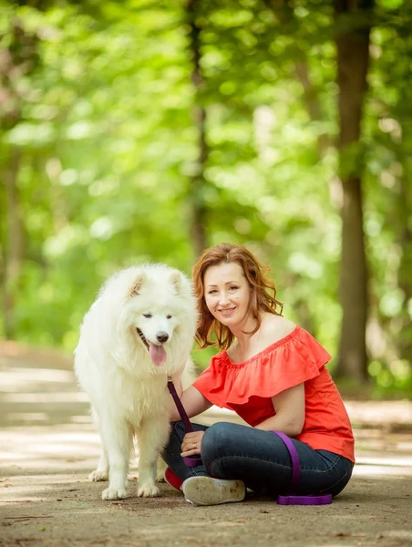 Kvinna med samojed hund rasen i parken — Stockfoto