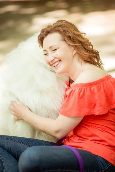 Mujer con raza de perro Samoyedo en el parque —  Fotos de Stock