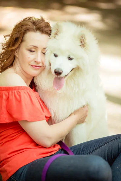 Kvinna med samojed hund rasen i parken — Stockfoto