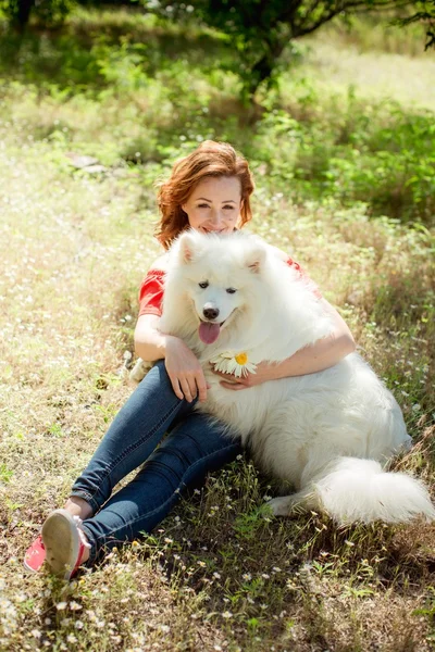 Kvinna med samojed hund rasen i parken — Stockfoto