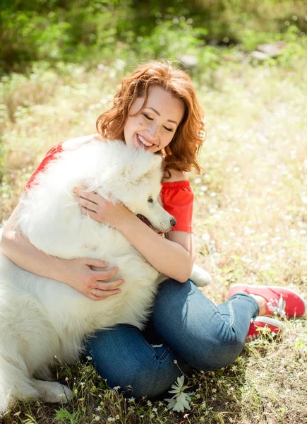 Donna con cane di razza Samoyed nel parco — Foto Stock