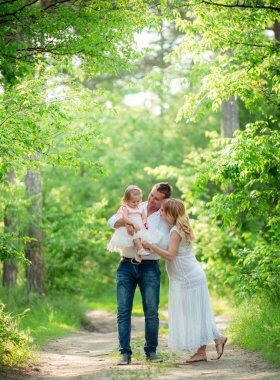 Hamile kadınla kocası ve kızı bahçede