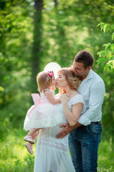 Donna incinta con il marito e la figlia in giardino — Foto Stock