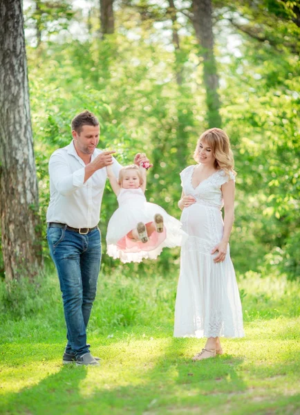 Kobieta w ciąży z mężem i córką w ogrodzie — Zdjęcie stockowe