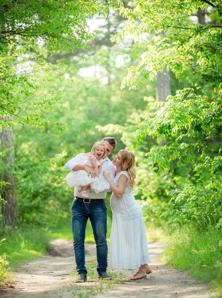 Donna incinta con il marito e la figlia in giardino — Foto Stock