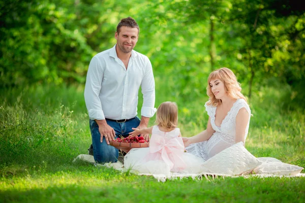 Zwangere vrouw met haar man en dochter in tuin — Stockfoto