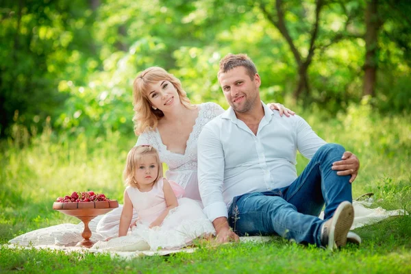 Schwangere mit Mann und Tochter im Garten — Stockfoto