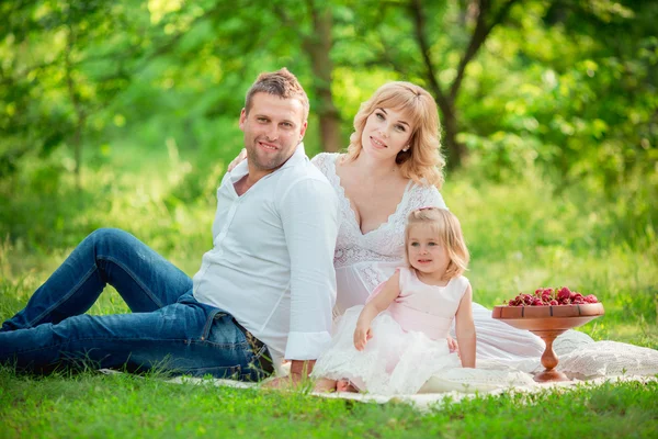 Zwangere vrouw met haar man en dochter in tuin — Stockfoto