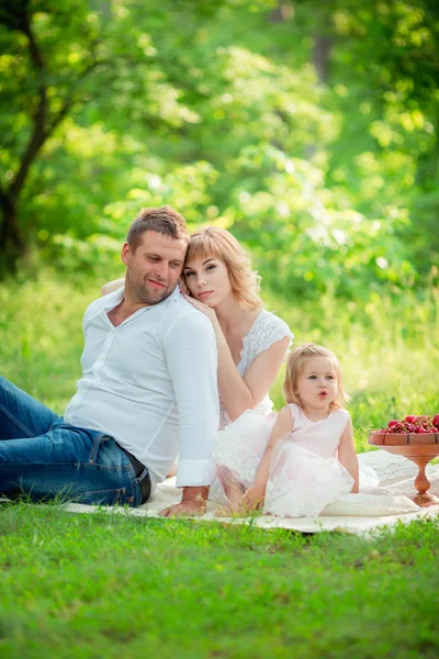 Gravid kvinne med mann og datter i hagen – stockfoto