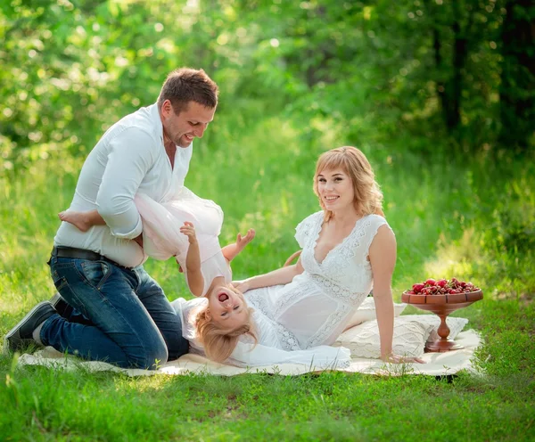 Mulher grávida com o marido e a filha no jardim — Fotografia de Stock