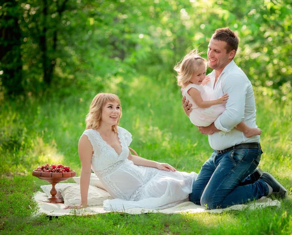 Kobieta w ciąży z mężem i córką w ogrodzie — Zdjęcie stockowe