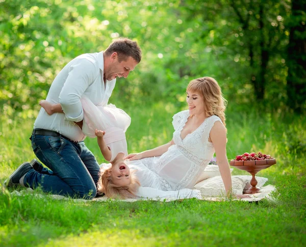 Donna incinta con il marito e la figlia in giardino — Foto Stock
