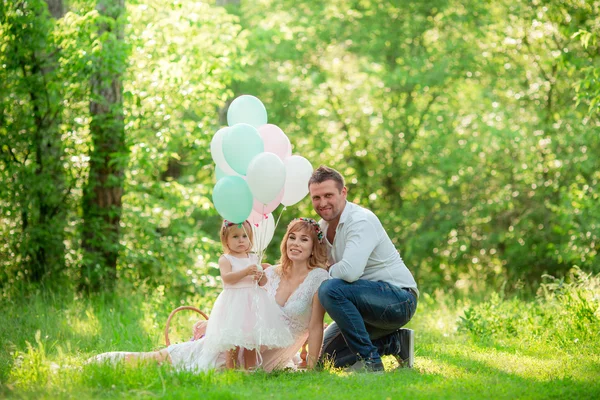 Zwangere vrouw met haar man en dochter in tuin — Stockfoto