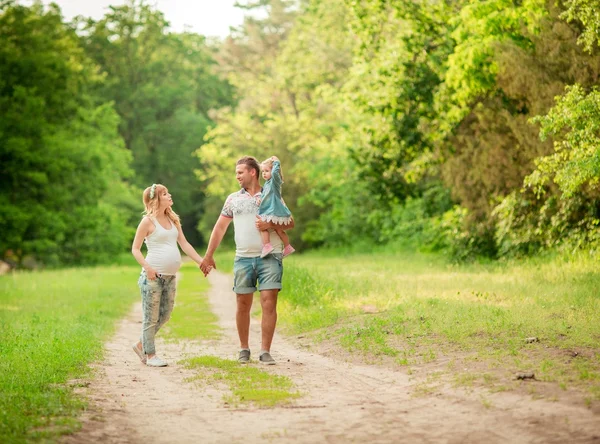 Donna incinta con il marito e la figlia in giardino — Foto Stock