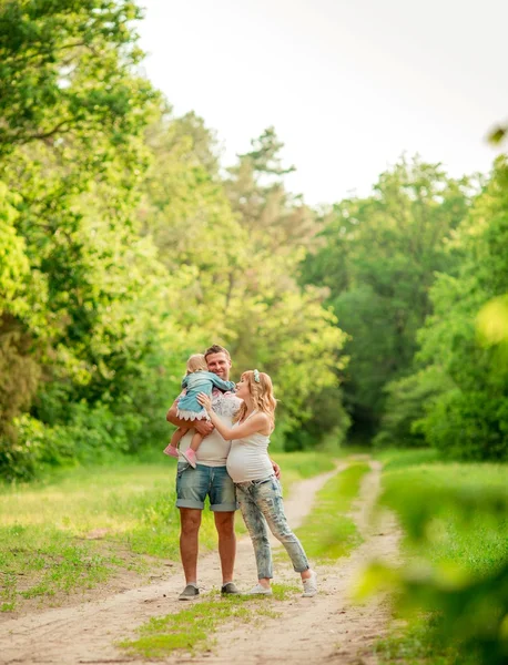 Donna incinta con il marito e la figlia in giardino — Foto Stock