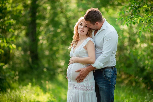 Kobieta w ciąży z mężem w ogrodzie — Zdjęcie stockowe