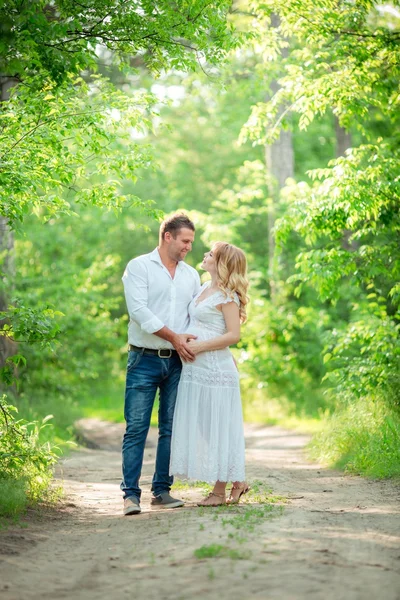 Schwangere mit Ehemann im Garten — Stockfoto