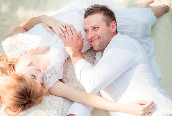 Zwangere vrouw met haar echtgenoot in de tuin — Stockfoto