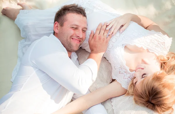 Zwangere vrouw met haar echtgenoot in de tuin — Stockfoto