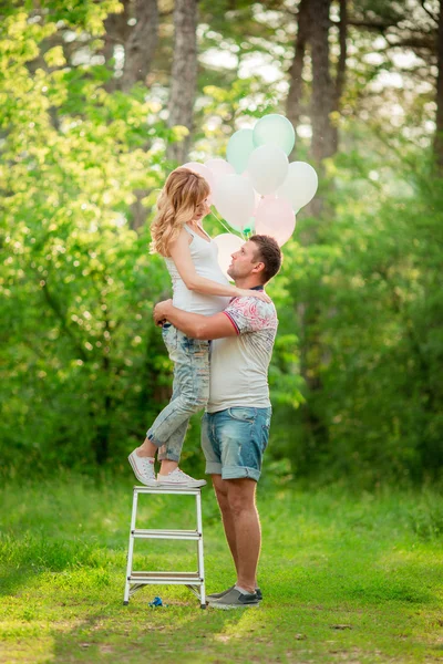 Těhotná žena se svým manželem v zahradě — Stock fotografie