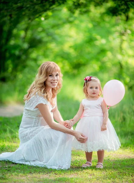 Donna incinta con giovane figlia in giardino — Foto Stock