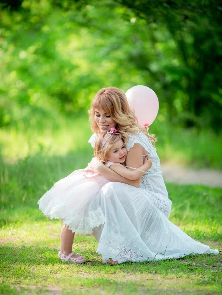 Pregnant woman with young daughter in garden — Stock Photo, Image