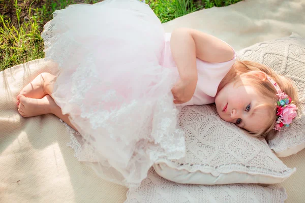 Menina de vestido branco deitado ao ar livre — Fotografia de Stock