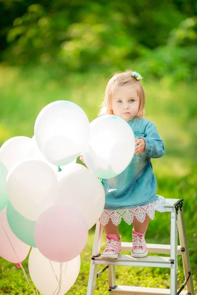 Kleines glückliches Mädchen mit Luftballons — Stockfoto